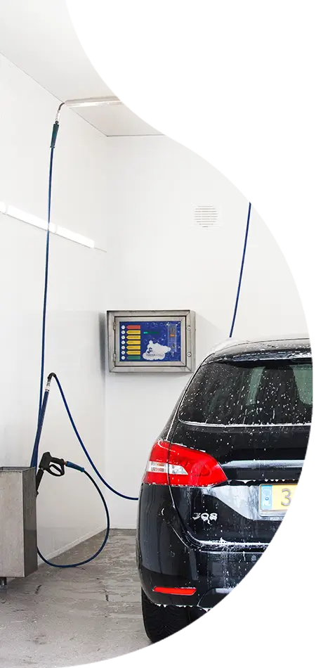 zwarte auto in een wasbox die bekleed is met witte, kunststof wasbox panelen